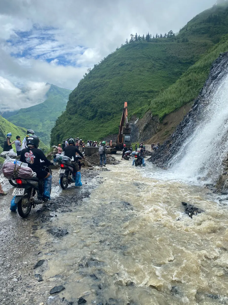 A massive waterfall created a river on the road on the Ha Giang Loop in Vietnam. Everyone who was riding or renting a motorbike in Vietnam needed to carefully cross the raging river. 