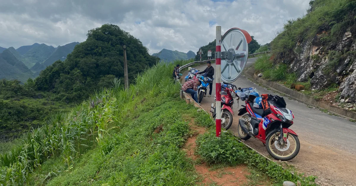 4 motorbikes and 3 easy drivers from the Ha Giang Vision tour company next to a guard rail on a pit stop.