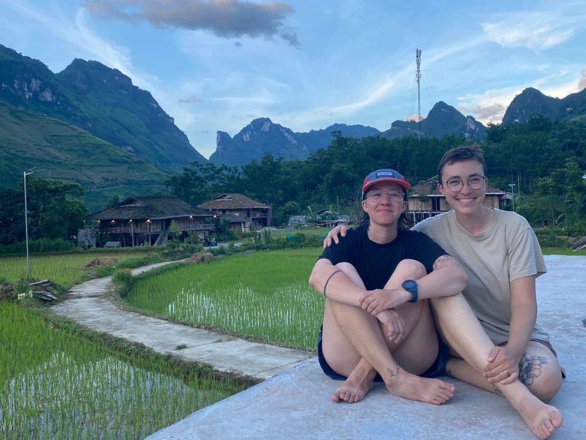 Knox & Haley sitting on a concrete patio overlooking the rice paddies in Ha Giang Vietnam