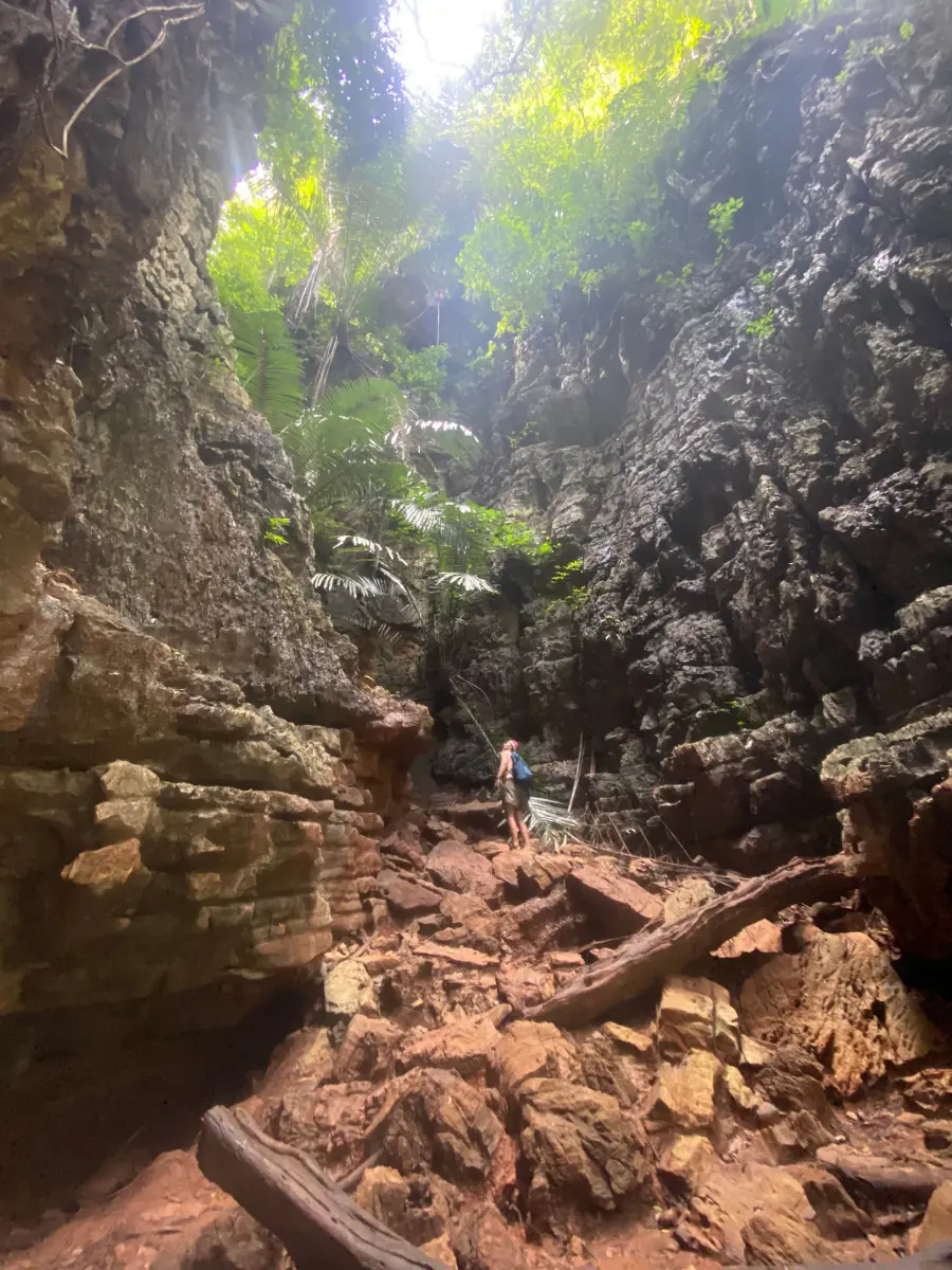 A person looking up at the almost vertical rock wall at Railay Beach Lagoon trail